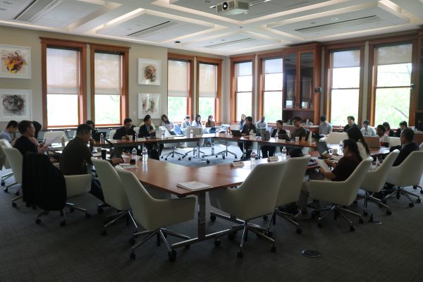 Roundtable with speakers sitting around it for a workshop on higher education.